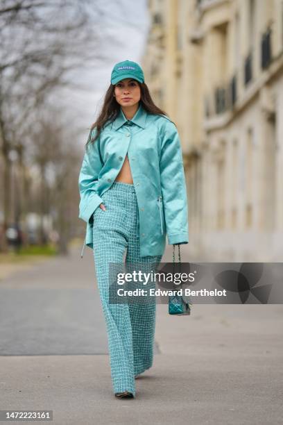 Guest wears a green denim with embroidered purple Mexicana pattern cap, a blue silk shirt from Chanel, a blue shiny silk / satin quilted pattern...