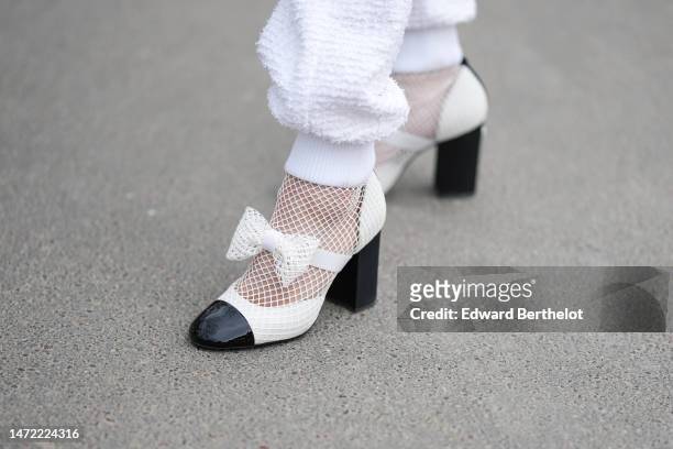Guest wears white tweed pants from Chanel, white shiny leather and black toe-cap with embroidered mesh / fishnet socks ankle shoes from Chanel,...