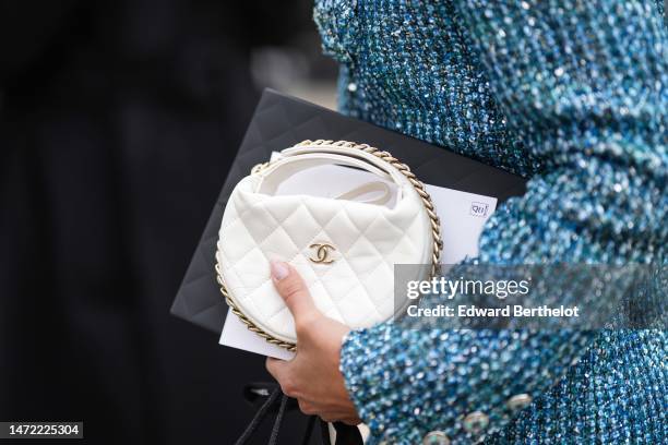 Guest wears a blue / black / white tweed jacket tweed dress from Chanel, a black shopping bag from Chanel, outside Chanel, during Paris Fashion Week...