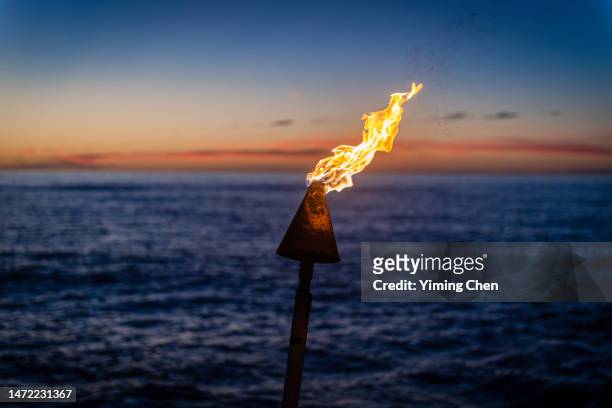 burning tiki torch in the dusk - big island hawaii islands stock-fotos und bilder