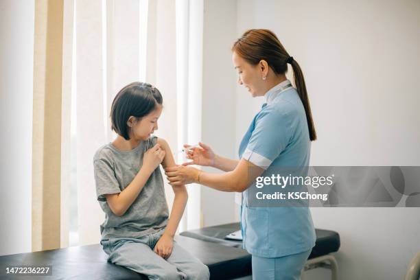 female doctor is doing an injection to little girl. - meningitis stock pictures, royalty-free photos & images