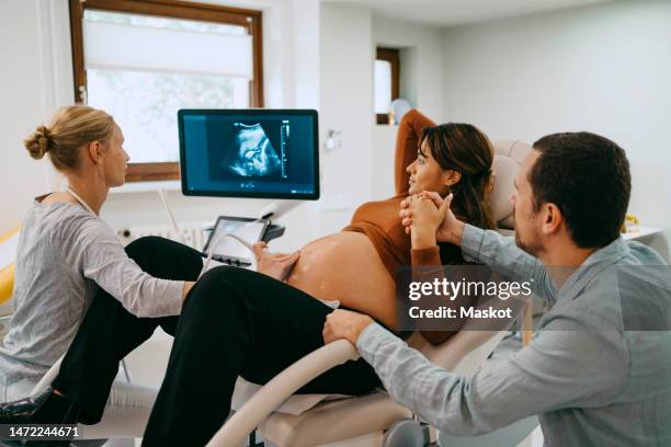 doctor doing ultrasound of pregnant woman lying down at maternity clinic - ultraljud bildbanksfoton och bilder