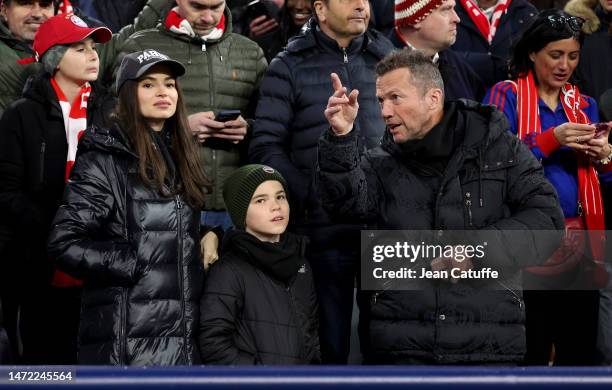 Lothar Matthaus and Anastasia Klimko - wearing a 'Paris' cap - attend the UEFA Champions League round of 16 leg two match between FC Bayern Munich...