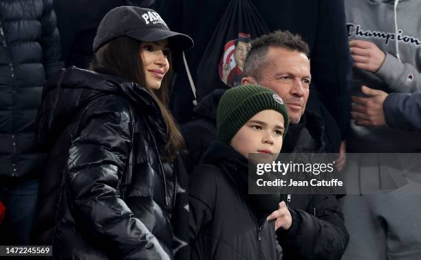 Lothar Matthaus and Anastasia Klimko - wearing a 'Paris' cap - attend the UEFA Champions League round of 16 leg two match between FC Bayern Munich...