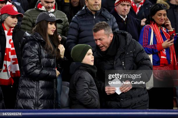 Lothar Matthaus and Anastasia Klimko - wearing a 'Paris' cap - attend the UEFA Champions League round of 16 leg two match between FC Bayern Munich...