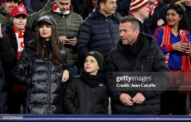 Lothar Matthaus and Anastasia Klimko - wearing a 'Paris' cap - attend the UEFA Champions League round of 16 leg two match between FC Bayern Munich...