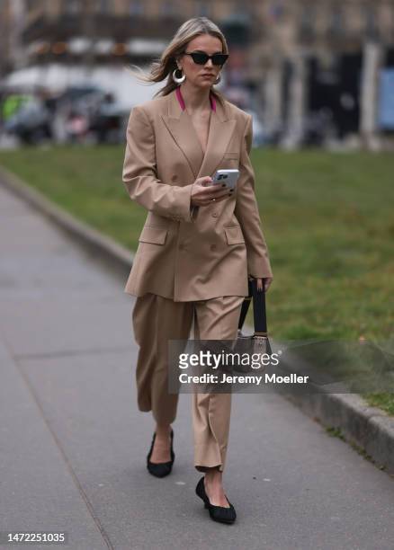 Kelly Sawyer Patricof seen wearing a beige suit, beige jacket, beige matchy pants and black heels and a beige animal printed bag outside Stella...
