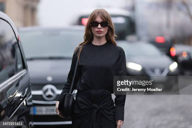 Ivy Getty seen wearing a full black outfit, black shirt, black wide pants, brown animal printed heels and black sunglasses and small bag outside...