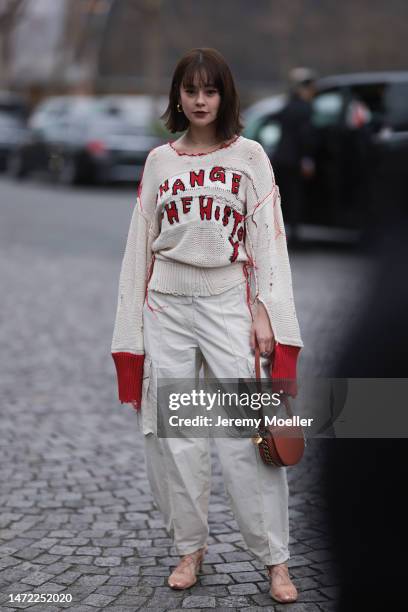 Emma seen wearing a white beige pullover with red details, beige wide pants, brown heels and a brown leather handbag, outside Stella McCartney during...