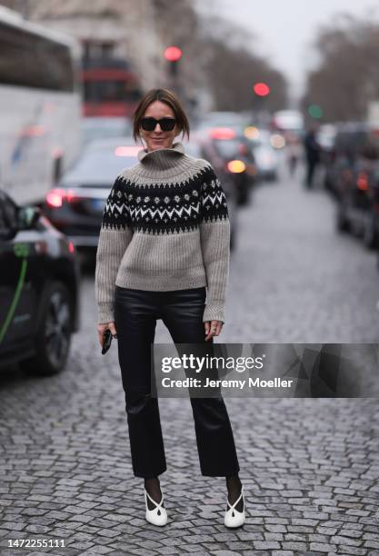 Fashion Week Guest seen wearing a beige and black pullover, black leather pants, white heels and black tights and sunnies, outside Stella McCartney...