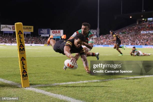 Brian To'o of the Panthers dives over to score a try as Isaiah Tass of the Rabbitohs attempts to tackle during the round two NRL match between the...