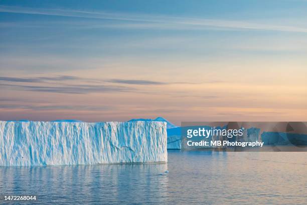 tabular icebergs at sunset in disko bay - global warming stock pictures, royalty-free photos & images