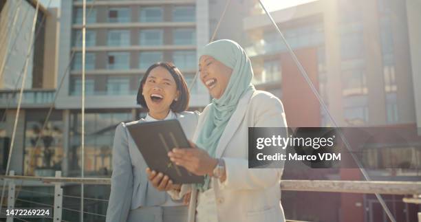 tablet, laughing and business women in city diversity communication, funny meme and internet in lens flare. asian professional and muslim partner on digital technology for international collaboration - funny muslim stock pictures, royalty-free photos & images