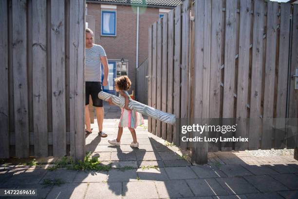 little girl helping dad with the picnic blanket - holland achtertuin stockfoto's en -beelden