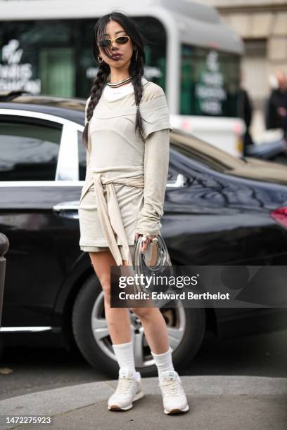 Guest wears beige sunglasses, silver earrings, a silver necklace, a white tank-top from Miu Miu, a pale brown long sleeves t-shirt, a pale khaki...