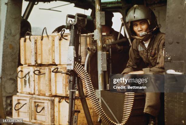 Government soldier sits next to crates of supplies aboard a helicopter in South Vietnam on February 4th, 1975.