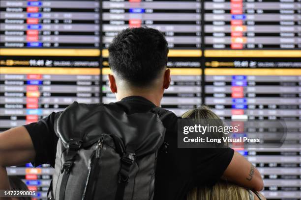 Couple watches the flight information boards after the low-cost airline Viva Air suspended its operations at the El Dorado International Airport in...