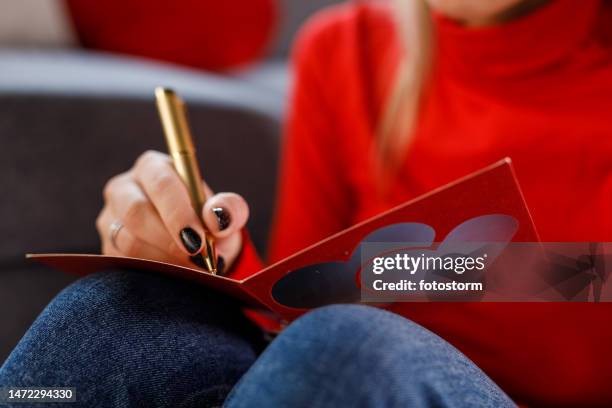 joven enamorada escribiendo una tarjeta de san valentín para un ser querido - carta de amor fotografías e imágenes de stock