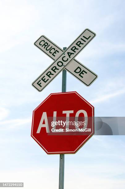 spanish-language railway crossing warning signs - cruce de ferrocarril/alto [railroad crossing/stop] - spanish language stock pictures, royalty-free photos & images