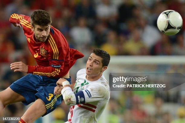 Portuguese forward Cristiano Ronaldo vies with Spanish defender Gerard Pique during the Euro 2012 football championships semi-final match Portugal vs...