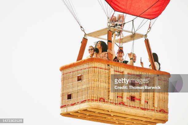 wide shot of family and friends on early morning hot air balloon ride - hot air balloon ride stock-fotos und bilder
