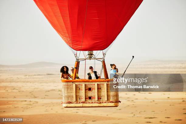 wide shot of family and friends on early morning hot air balloon ride - travel photos et images de collection