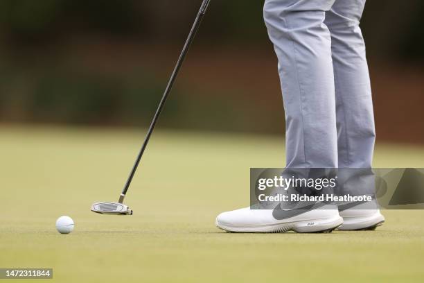 Detailed view of shoes worn by Rory McIlroy of Northern Ireland are seen as he putts during the first round of THE PLAYERS Championship on THE...