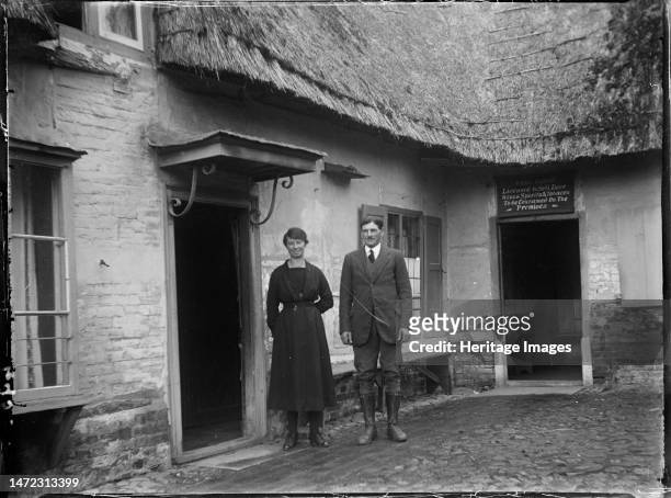 Royal Oak Inn, Wootton Rivers, Wiltshire, 1923. A portrait of Mr & Mrs Gilbert standing in the courtyard of the Royal Oak Inn. A sign above one of...