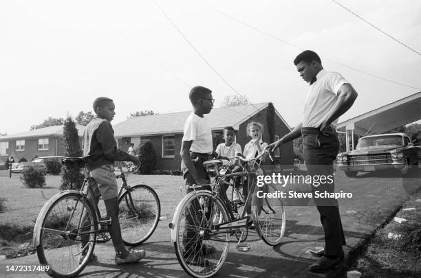 American Heavyweight boxer Cassius Clay talks with a group of neighborhood children, Louisville, Kentucky, 1963. Among them is 6-year old Yolanda...