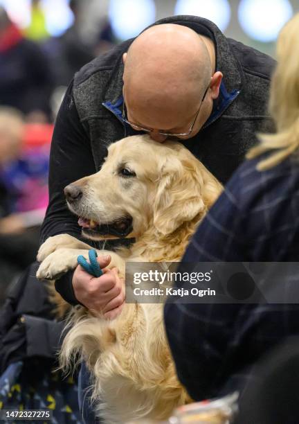 Man embraces his Golden Retriever on day 1 of CRUFTS Dog Show at NEC Arena on March 9, 2023 in Birmingham, England. Billed as the greatest dog show...