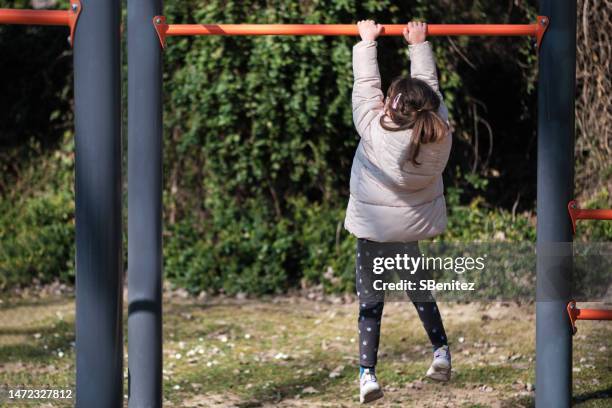 girl playing with playground equipment in park - playground balance beam stock pictures, royalty-free photos & images