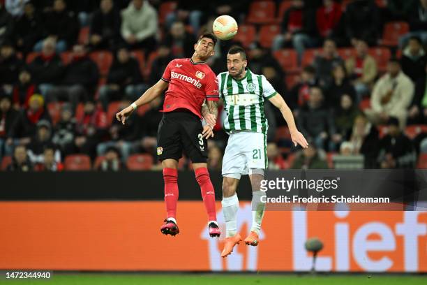 Piero Hincapie of Bayer 04 Leverkusen and Endre Botka of Ferencvarosi TC battle for a header during the UEFA Europa League round of 16 leg one match...