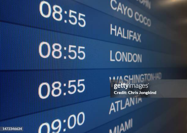 airport departure board showing the schedule of various outbound flights - london ontario photos et images de collection