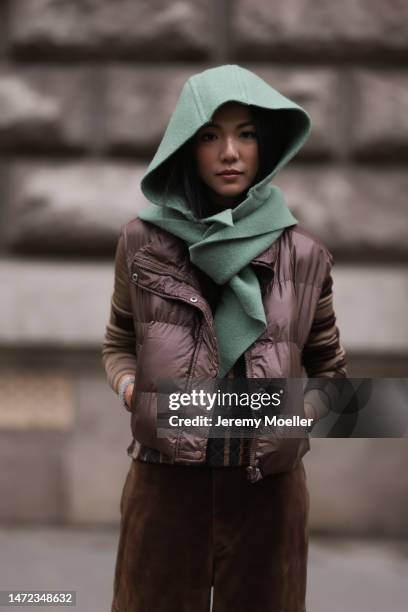 Yoyo Cao wears a brown puffed vest, brown suade cargo pants, turquoise scarf, outside Hermes, during Paris Fashion Week - Womenswear Fall Winter 2023...