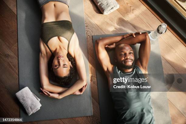 pareja negra, yoga y relájese en la colchoneta de arriba para el zen, el bienestar espiritual o el ejercicio pacífico juntos. hombre y mujer yogui en meditación fitness relajándose o acostado en el suelo en postura de cadáver o shavasana - yogi fotografías e imágenes de stock