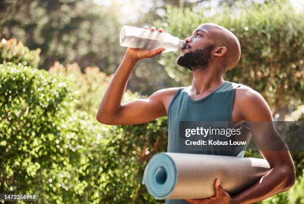 tapete de yoga, fitness e homem negro bebendo água na natureza para saúde e bem-estar ao ar livre. atleta, pilates e yogi masculino bebem líquido para hidratação após o exercício, treino ou exercício de treino. - groom human role - fotografias e filmes do acervo