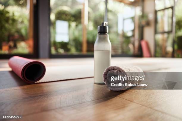 water, towel and yoga mat in an empty fitness studio for wellness, mental health or inner peace closeup. fitness, exercise and pilates with still life equipment on the floor of a gym for a workout - sport for life stock pictures, royalty-free photos & images