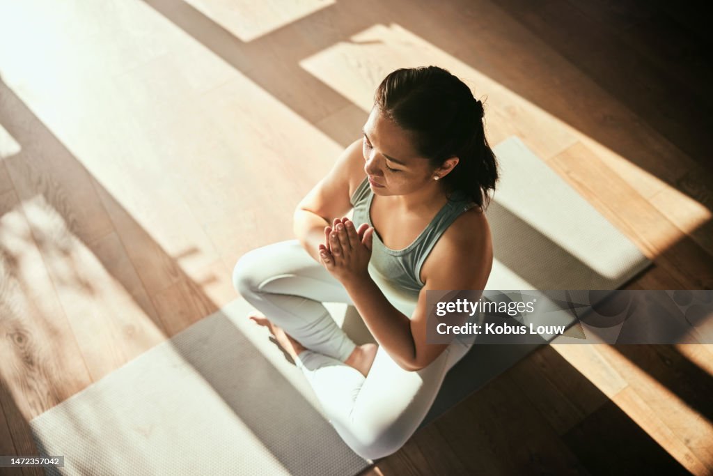 Meditazione, yoga e vista dall'alto della donna con le mani di preghiera in casa per la salute e il benessere. Medita namaste, chakra zen e allenamento yogi femminile, esercizio o allenamento per pilates, consapevolezza e pace