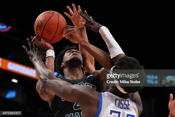 Mouhamadou Cisse of the Saint Louis Billikens and Ginika Ojiako of the George Mason Patriots fight for the rebound in the first half during the...