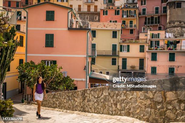 latin woman visiting beautiful town in cinque terre coast, italy - riomaggiore stock pictures, royalty-free photos & images