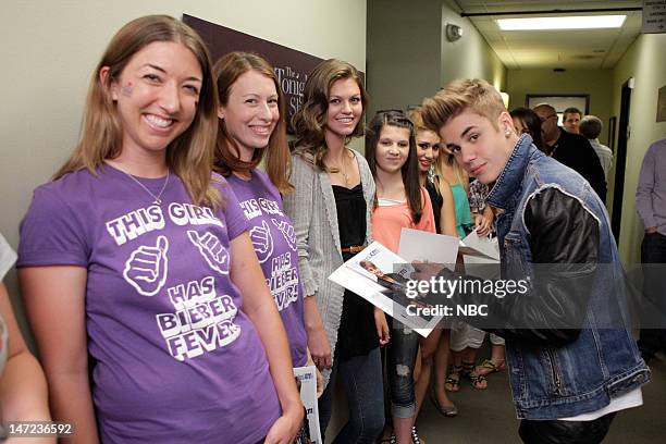 Episode 4279 -- Pictured: Musical guest Justin Bieber signs autographs for fans backstage on June 27, 2012 --