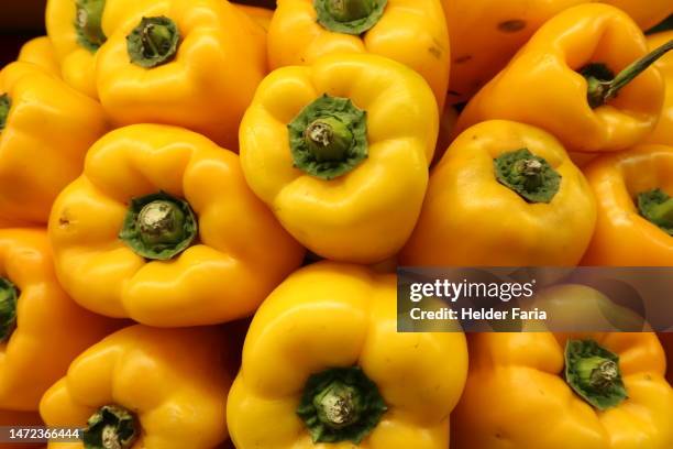 full frame of a pile of yellow peppers - yellow bell pepper stock pictures, royalty-free photos & images