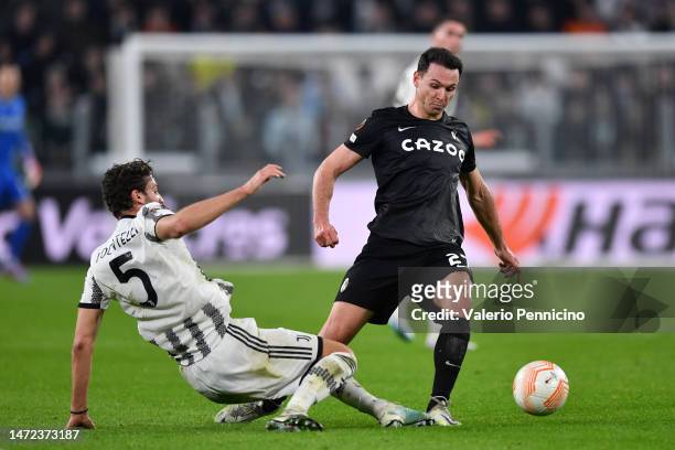 Nicolas Hoefler of Sport-Club Freiburg is challenged by Manuel Locatelli of Juventus during the UEFA Europa League round of 16 leg one match between...