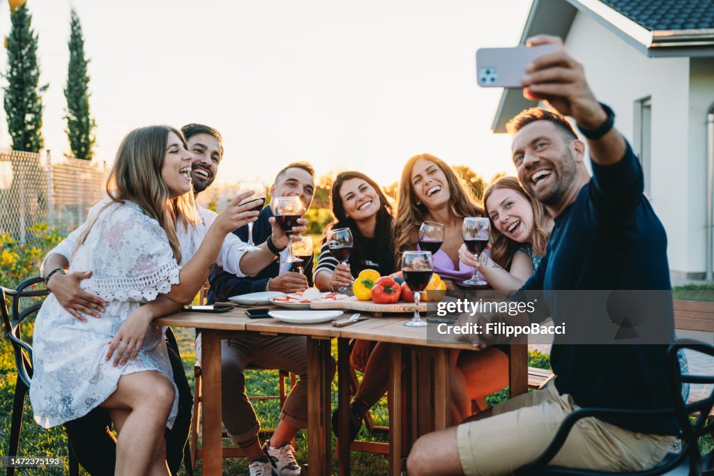 Amigos estão tirando uma selfie juntos durante um jantar
