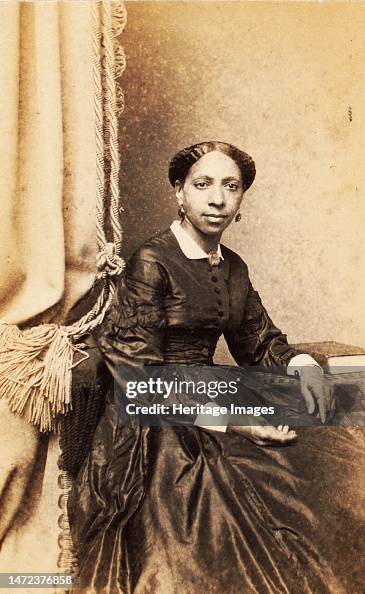 Portrait Of Woman Seated Next To Tasselled Curtain