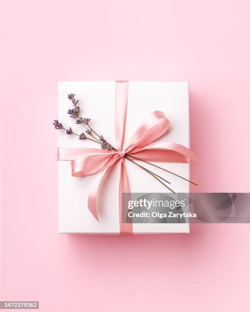 white gift box tied pink ribbon with lavender decorating on pink background. - gift box tag stock-fotos und bilder
