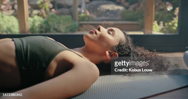 meditation, yoga and zen of black woman on a pilates studio floor for fitness and wellness. rest, relax and peace practice of a young person sleeping on the home gym ground for balance and chakra - man doing yoga in the morning stockfoto's en -beelden