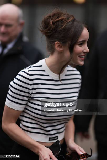 Alba Baptista seen wearing a black and white striped shirt and a black mini skirt before the Miu Miu show on March 07, 2023 in Paris, France.