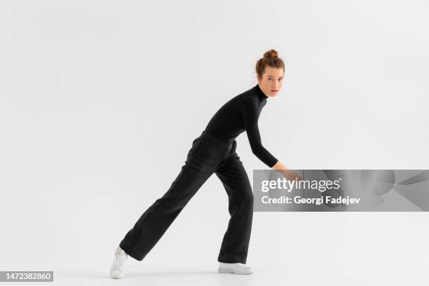 young girl, professional hip-hop dancer in a black clothes performing over a isolated white background with a plenty of copy space. - hip hopper stock pictures, royalty-free photos & images
