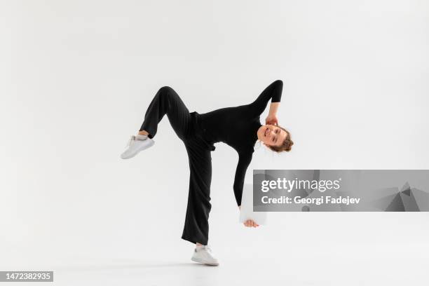 young girl, professional hip-hop dancer in a black clothes with blank white paper in the hand and performing over a isolated white background with a plenty of copy space. - learning agility stock pictures, royalty-free photos & images